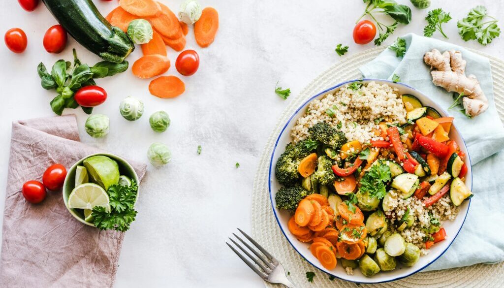 A variety of colorful fruits, vegetables, grains, and proteins on a plate, representing a balanced diet for optimal health and weight management.