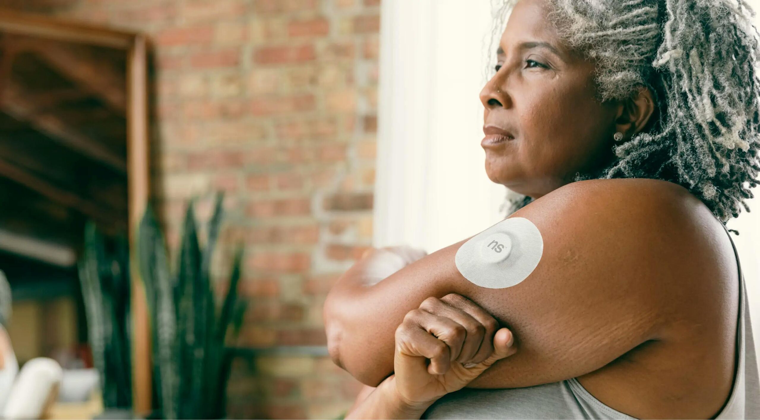 Person wearing a continuous glucose monitor on their hand, monitoring blood sugar levels in real-time.