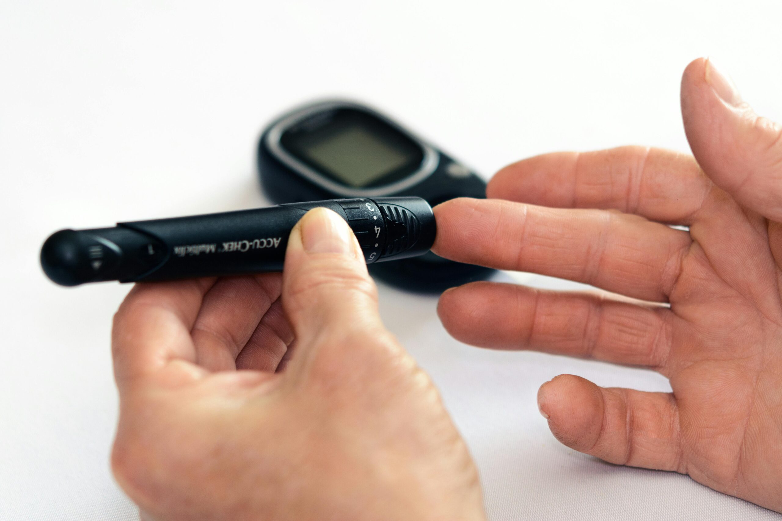 Person using a glucometer to self-monitor glucose levels at home, demonstrating blood sugar testing for diabetes management.